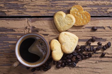 Fincan kahve ve kalp şeklinde kurabiye kurabiye vintage ahşap arka plan, üstten görünüm