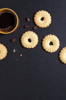 Siyah bir taş zemin üzerine havai görünümü kahve Kupası ve lezzetli kurabiye kurabiye. Aşağıda orada metin için bir yer