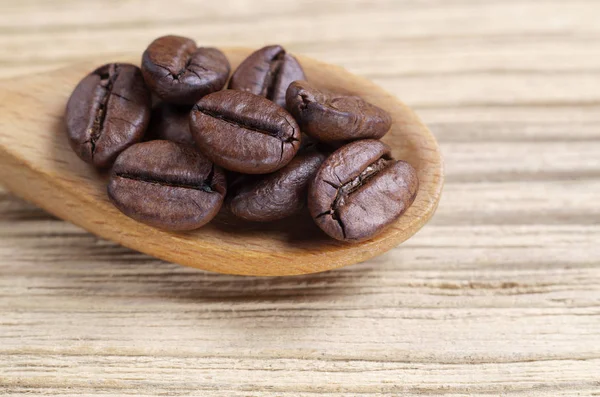 Rostade Kaffebönor Sked Trä Bakgrund Närbild — Stockfoto