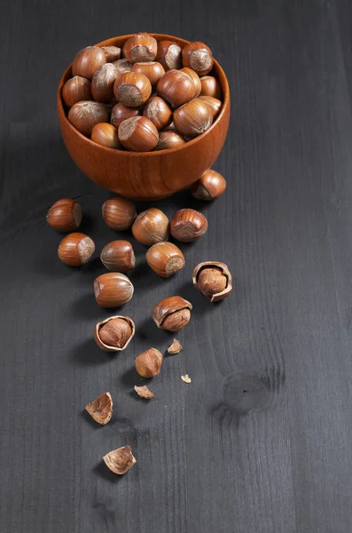 Lískové Ořechy Kuželky Rozptýlené Celé Popraskané Nachází Černý Dřevěný Stůl — Stock fotografie