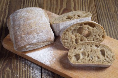 Ciabatta ekmek ve ahşap bir masa üzerinde bir kesme tahtası dilimleri