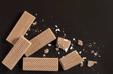 Çikolatalı gofret bütün ve kırık eski siyah metal arka plan ile üstten görünüm üzerinde metin için yer