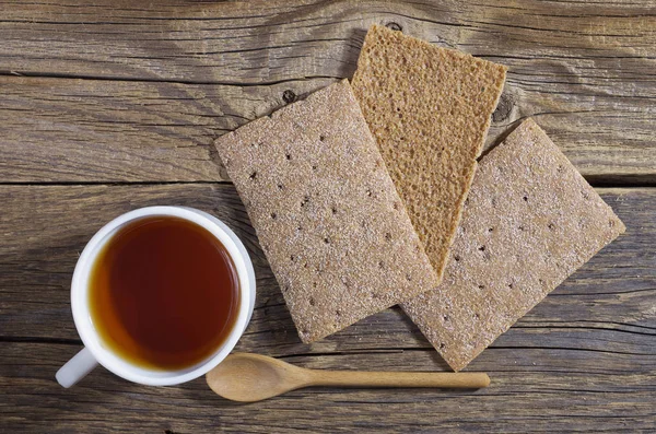 一杯の紅茶と古い木製のテーブル トップ ビューではダイエット食品茶色のぱりっとしたパン — ストック写真