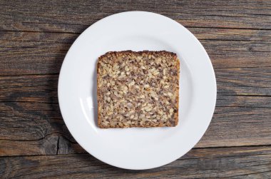 Eski ahşap arka plan, üstten görünüm üzerinde bir tabak içinde farklı tohumları ile ekmek dilimi 