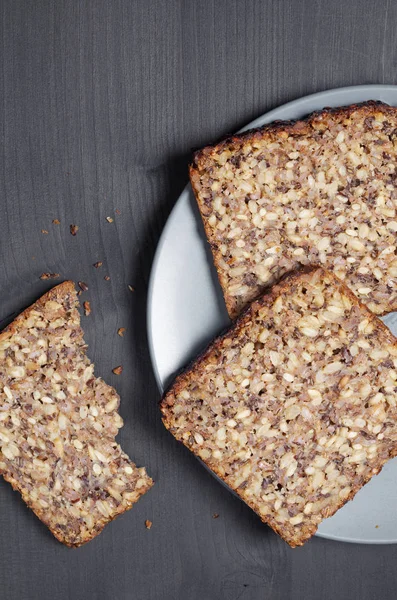 Sneetjes Brood Met Verschillende Zaden Een Grijze Plaat Zwarte Houten — Stockfoto