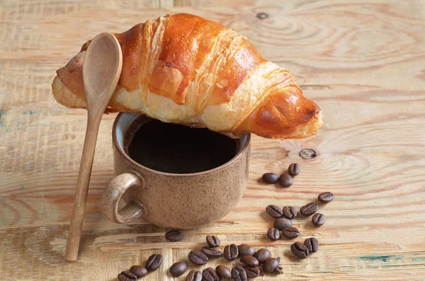 Croissant saboroso e xícara de café — Fotografia de Stock
