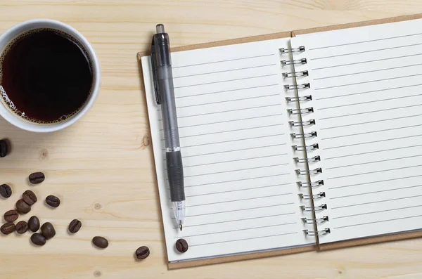 Cuaderno abierto con bolígrafo y café — Foto de Stock