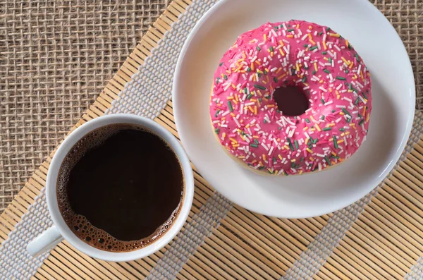 Kaffee und rosa Donut — Stockfoto