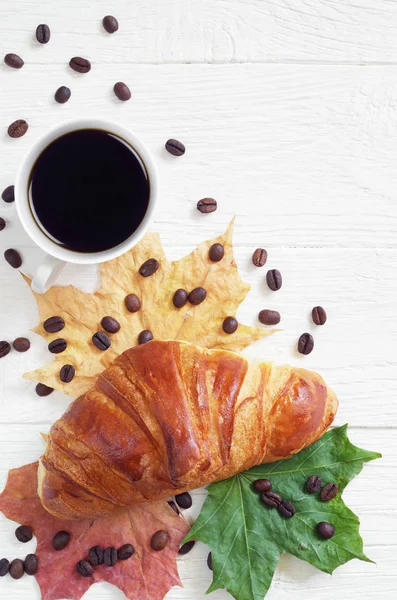 Croissant, kaffe och löv — Stockfoto