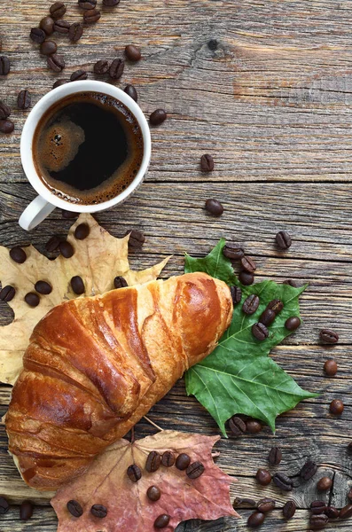 Круассан, кофе и листья — стоковое фото