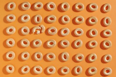 Turuncu arka planda sıralanmış küçük simitler, üst manzara