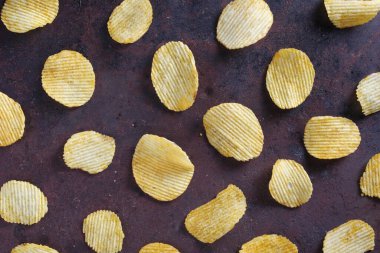 Eski metal arka planda tırtıklı patates cipsi.