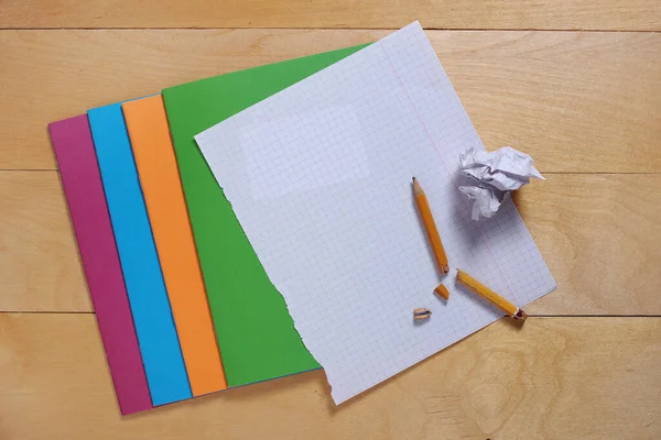 木制书桌上的学校笔记本和破铅笔 顶部视图 — 图库照片