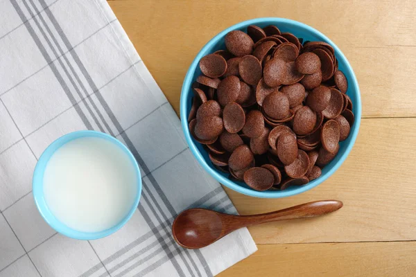 就在眼前的巧克力玉米片放在碗里 牛奶放在木桌上 — 图库照片