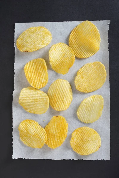 Salty Ribbed Potato Crisps Paper Black Background Close Top View — Stock Photo, Image