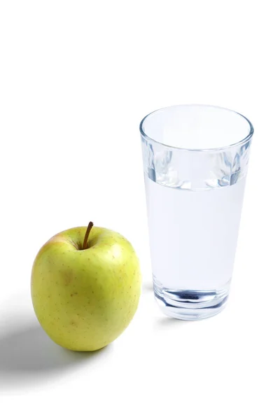 白い背景に緑のリンゴと水のガラスのクローズアップ — ストック写真
