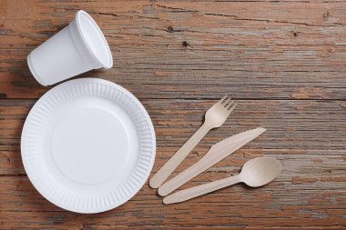 Eski ahşap masadaki tek kullanımlık tabakların tam üstünde. Boşluğu kopyala