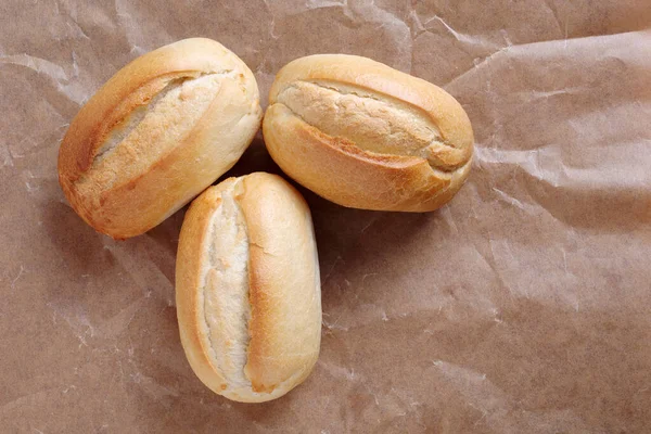 Trzy Bochenki Małego Chleba Pszennego Pogniecionym Papierowym Tle Widok Góry — Zdjęcie stockowe