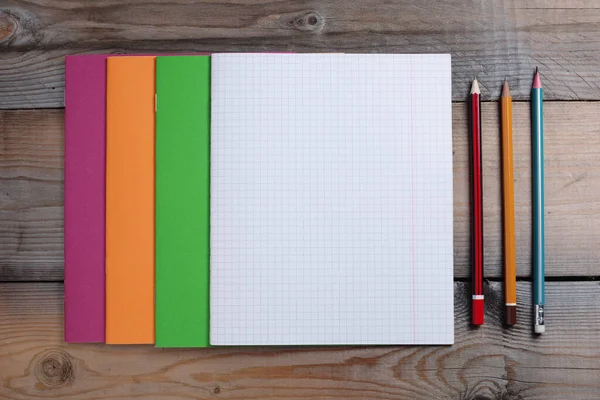 木制背景的色彩斑斓的学校笔记本和铅笔 顶级竞赛 — 图库照片
