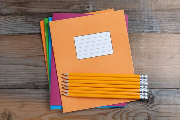 Πολύχρωμα Σχολικά Σημειωματάρια Και Μολύβια Ξύλινο Φόντο Top View — Φωτογραφία Αρχείου