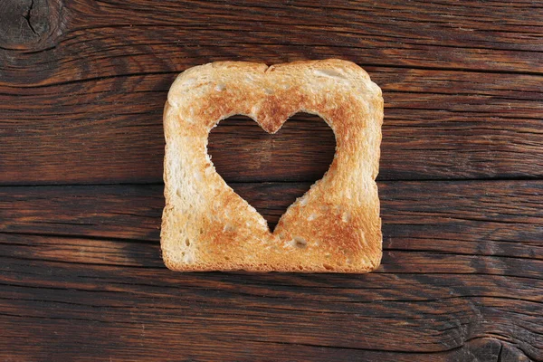 Ahşap Arka Planda Kalp Şeklinde Kesilmiş Kızarmış Ekmek — Stok fotoğraf