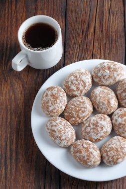 Tabakta zencefilli kurabiye ve tahta arka planda bir fincan kahve.