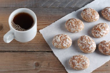Yüksek açılı kahve fincanı ve ahşap masada zencefilli kurabiye.