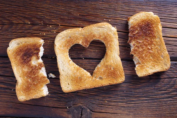 Kalp Şeklinde Bir Tost Ekmeği Ahşap Arka Planda Iki Yarısı — Stok fotoğraf