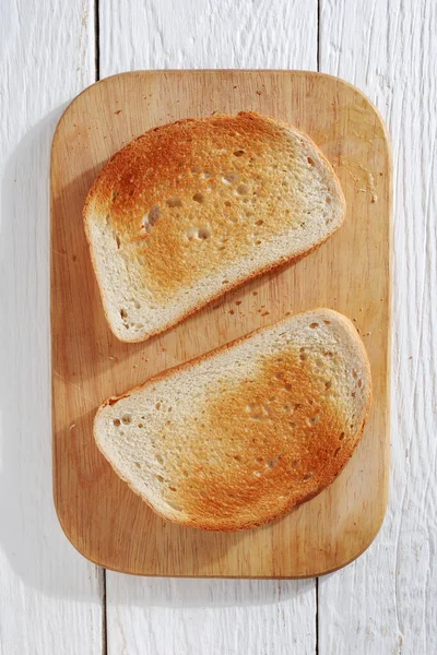 Dva Plátek Toastu Řezací Desce Bílém Dřevěném Stole Pohled Shora — Stock fotografie