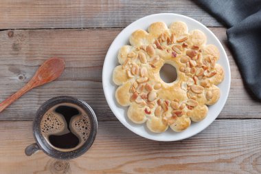 Kurabiye ve fındık ve bir fincan kahve, ahşap masa, üst manzara.