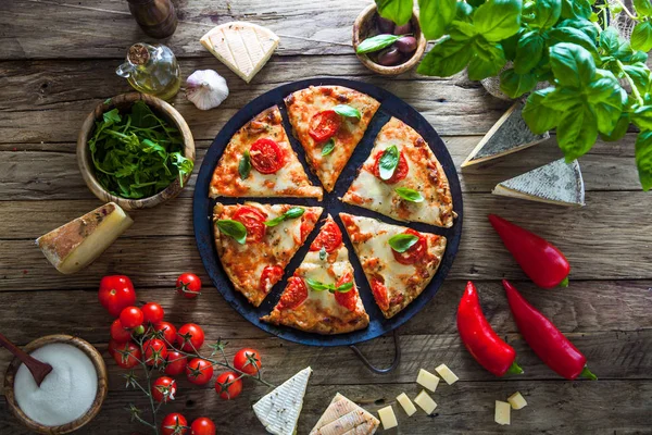 Pizza sobre madera con ingredientes — Foto de Stock