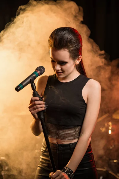 Singing woman on stage, smoke on background