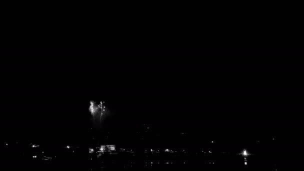 黒と白の海岸沿いの町の上のビーチからの花火のタイムラプス 4Kフッテージ — ストック動画