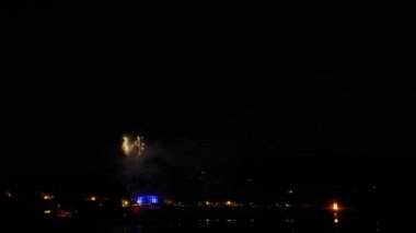 Bir sahil kasabası üzerinde bir plajdan bir firework timelapse. Görüntülerin ortasındaki kıvılcımları aşamalı olarak yakınlaştırma. Hd 1080p.