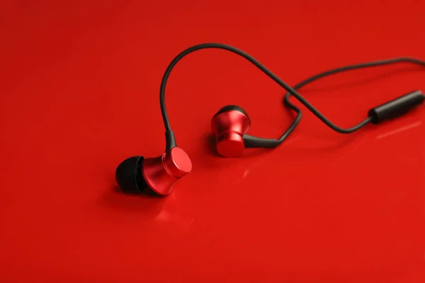 Rot Gefärbte Verdrahtete Kopfhörer Auf Rotem Hintergrund — Stockfoto
