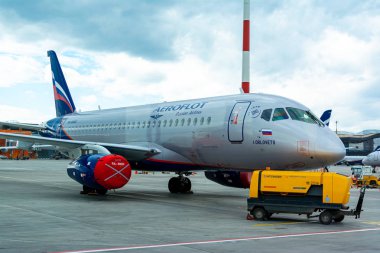 Bir yolcu uçağı kalkış bekleyen bir park alanında havaalanında ayakta, uçuş için hazırlık süreci devam ediyor