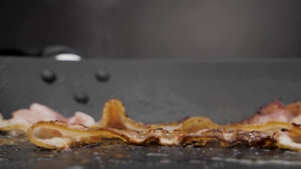 Baconet är stekt i en kastrull. — Stockvideo
