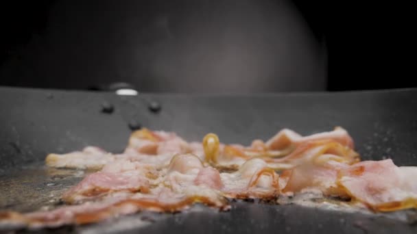 Baconet är stekt i en kastrull. — Stockvideo