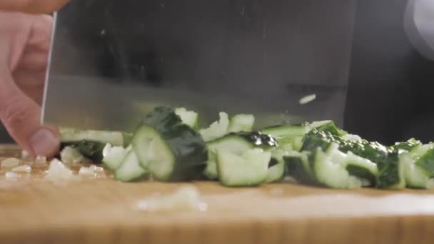 Hand raakt een komkommer met een groot mes — Stockvideo