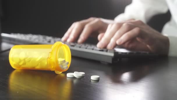 Man is typing on a keyboard. Pills in the foreground — Stock Video