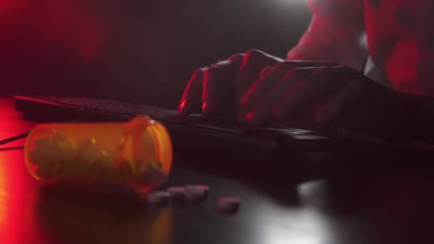 Mann tippt auf einer Tastatur. Pillen im Vordergrund — Stockvideo