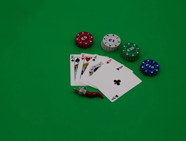 Poker kaarten en amuletten op een groene tafel — Stockfoto