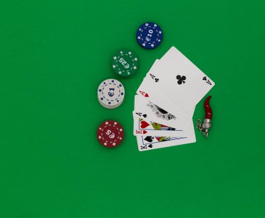 Poker kartları ve tılsım yeşil bir masada.