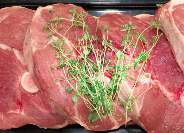 Friss Nyers Vörös Hús Márvány Steak Fekete Tálcán Zöld Fűszerekkel — Stock Fotó