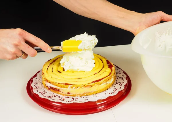 Person Die Einen Schichtkuchen Auf Einem Roten Plastikblech Herstellt — Stockfoto