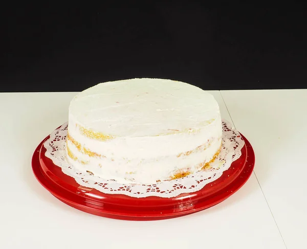 赤いプラスチックトレイに層ケーキを作成する人 — ストック写真