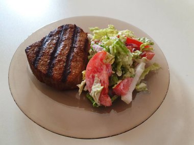 Beyaz masada sebzeli ızgara et.