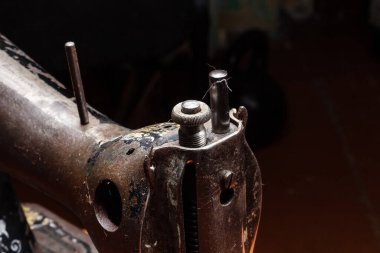 Bir rafta eski bir dikiş makinesi saklanır.