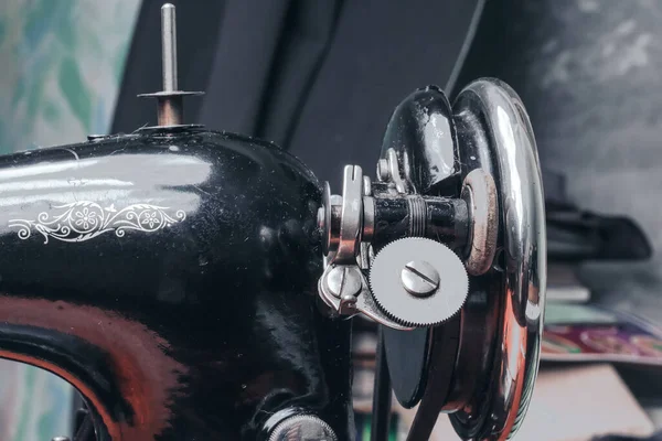 A sewing vintage mechanical machine is stored on a shelf.