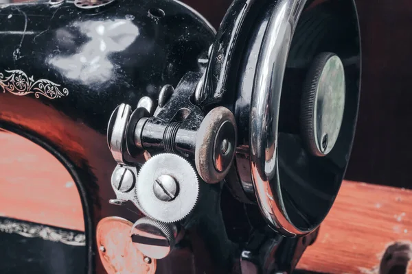 A sewing vintage mechanical machine is stored on a shelf.